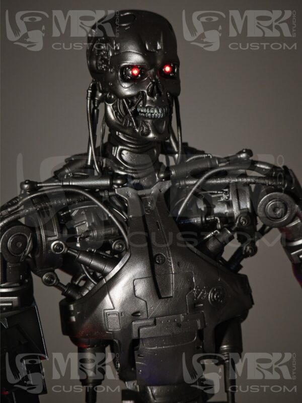 Close-up of T-800 Endoskeleton head with LED-lit red eyes and hand-painted metal finish.