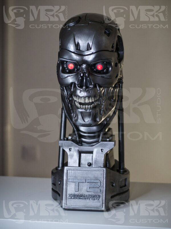 1:1 scale Terminator T-800 head statue with glowing red LED eyes and metallic detailing.