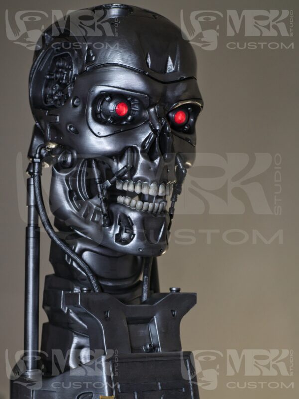 1:1 scale Terminator T-800 head statue with glowing red LED eyes and metallic detailing.